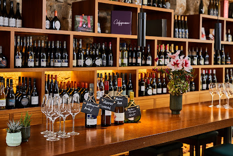 Vinothek mit Weinglaesern und Weinflaschen im Weinforum Franken