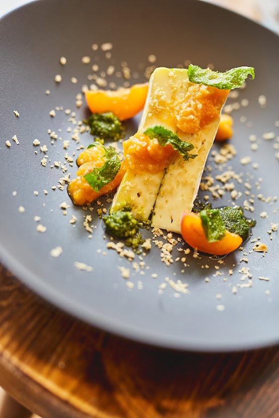 Kunstvoll angerichtetes Dessert mit Aprikosen und Minze auf dunklem Teller – Restaurant Weinforum Franken Eibelstadt